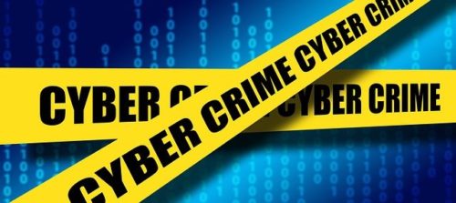 Yellow barricade tape with 'Cyber Crime' written on it against a blue coding background. There are many expected coronavirus cyberthreats in 2021.