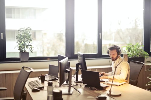 An IT support man sits at his desk on his computer. Outsourcing your IT services provides many benefits.