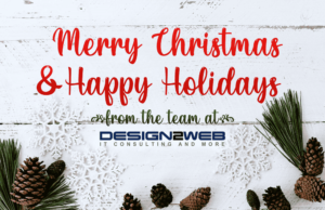 White wooden panel with "Merry Christmas & Happy Holidays from the team at Design2Web" amongst pinecones and snowflakes.