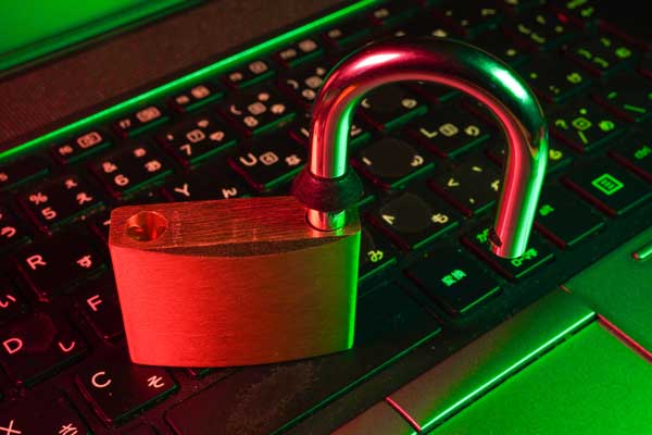 Open padlock on keyboard, cybersecurity vulnerabilities concept.